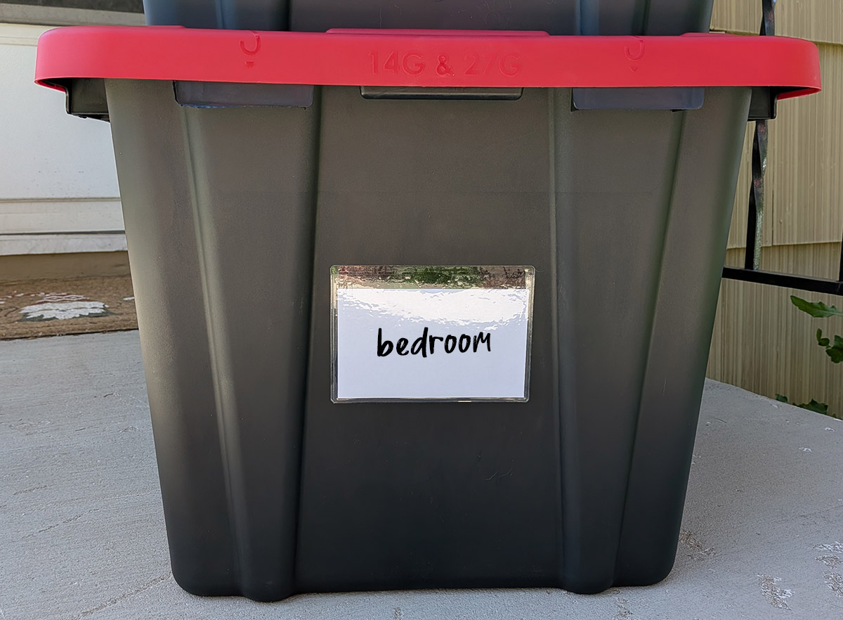 Close up of tote showing a label with the word "bedroom" on it.