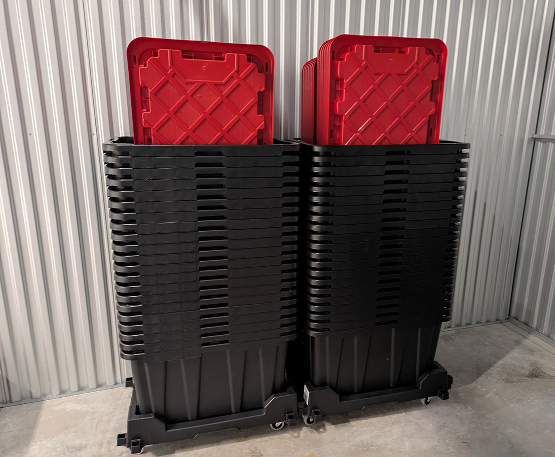 Two stacks of black and red moving totes from Twin Cities Tote Rental's inventory